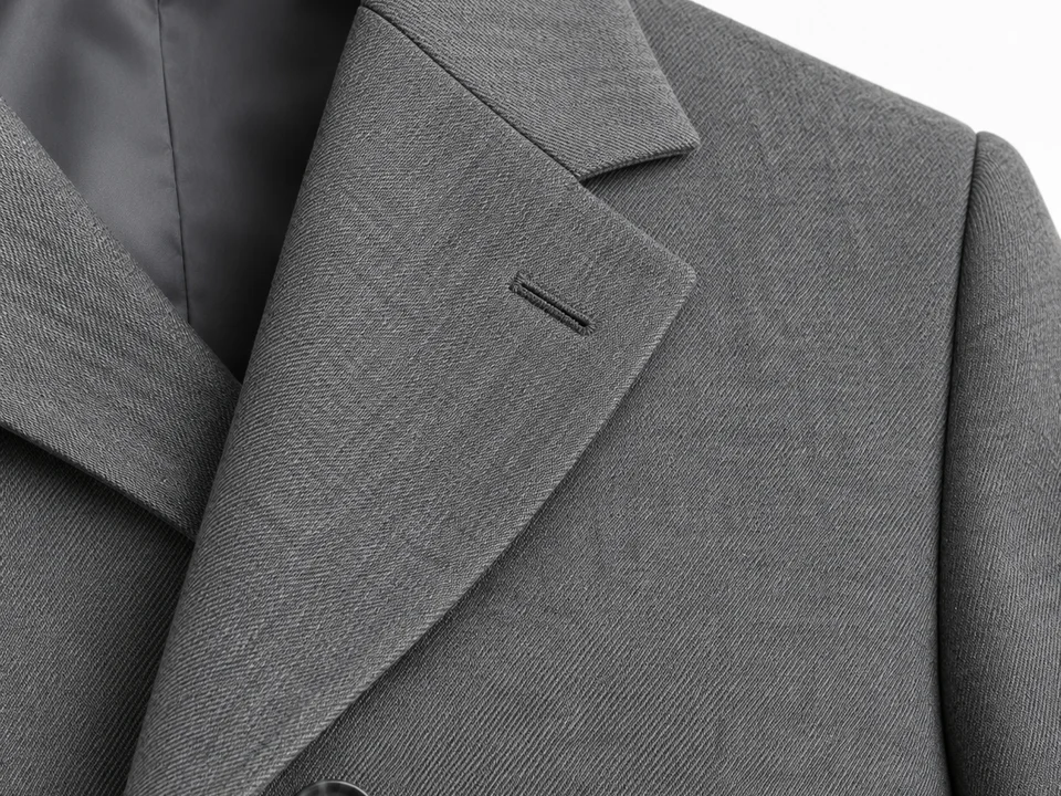 Detalle de la solapa de muesca y el ojal de una chaqueta gris